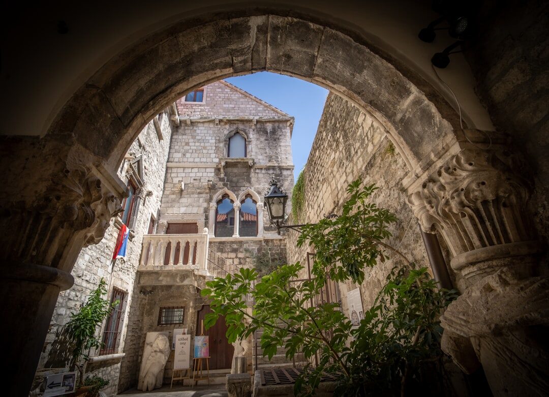 Sunlit harbor in Split with old stone buildings and boats