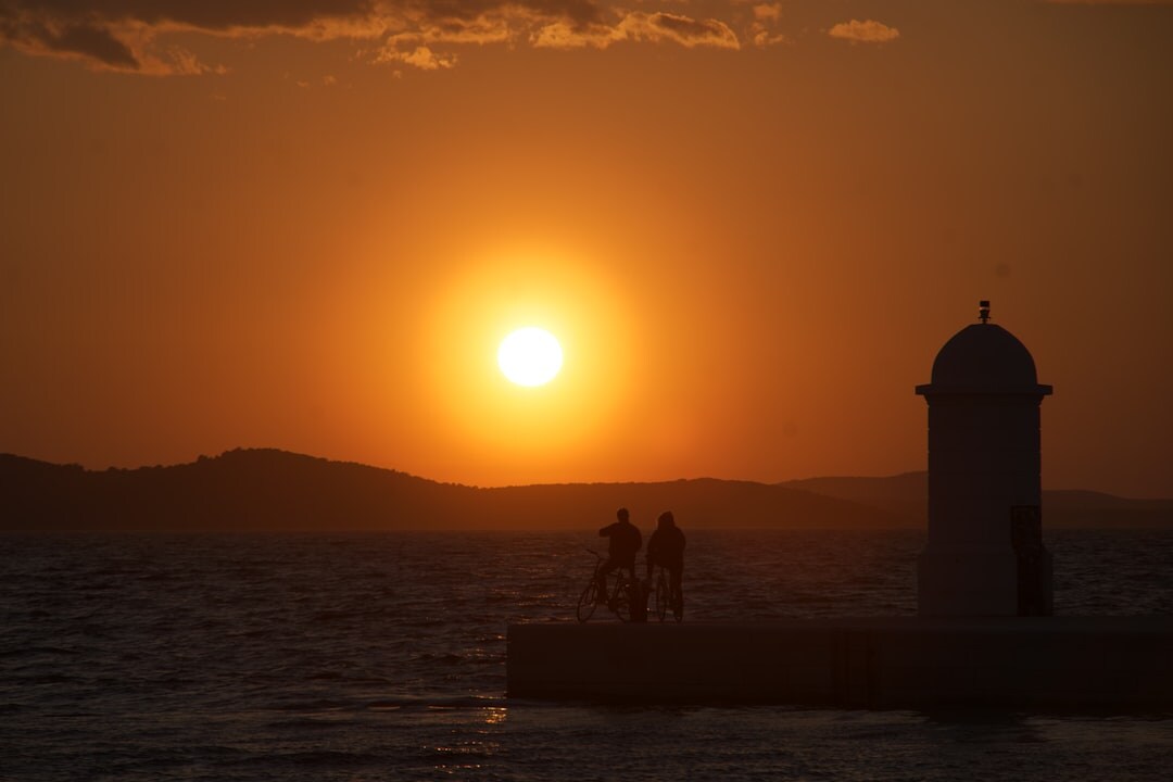 Fishermen mending nets on a Croatian dock at dawn