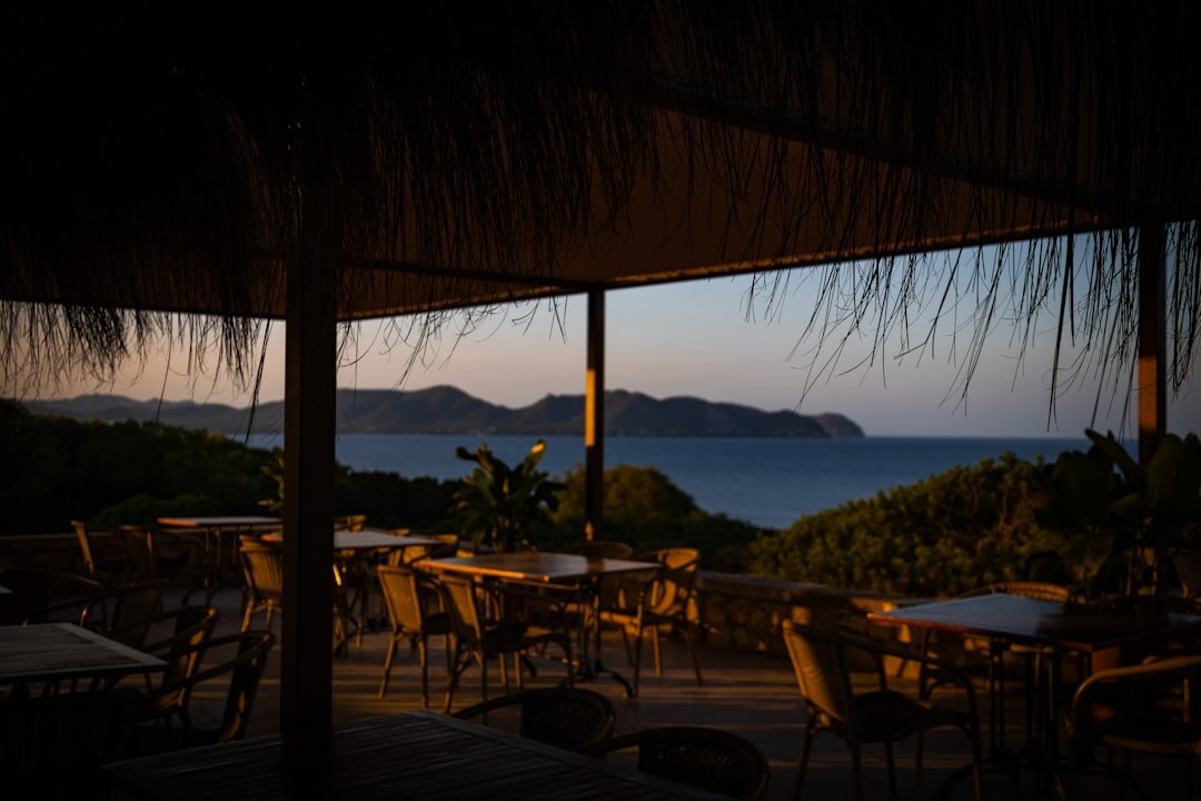 Coastal cafe terrace with wicker chairs by the sea