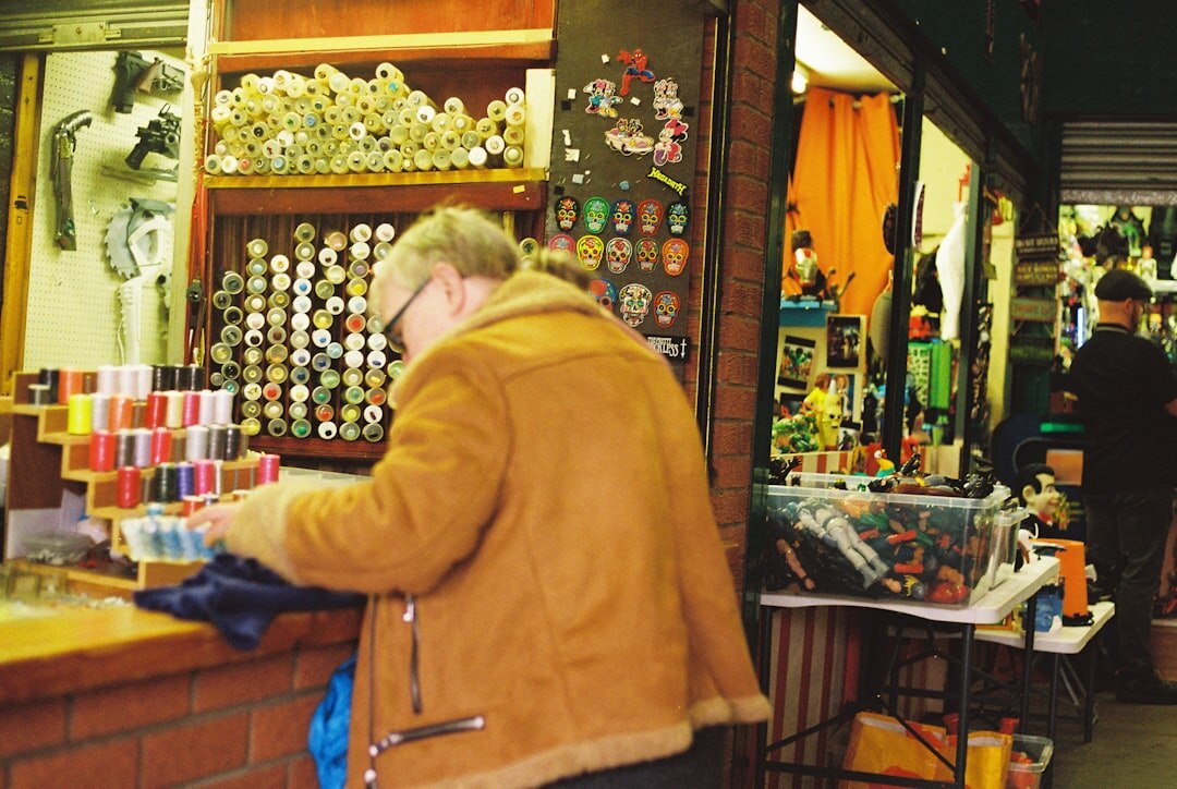 Shopkeeper arranging olive oil bottles in a small shop