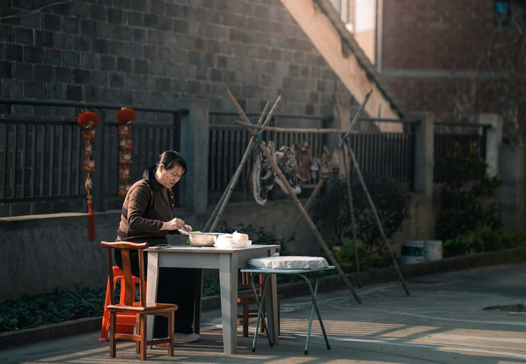 Elderly men playing cards at an outdoor table in a village