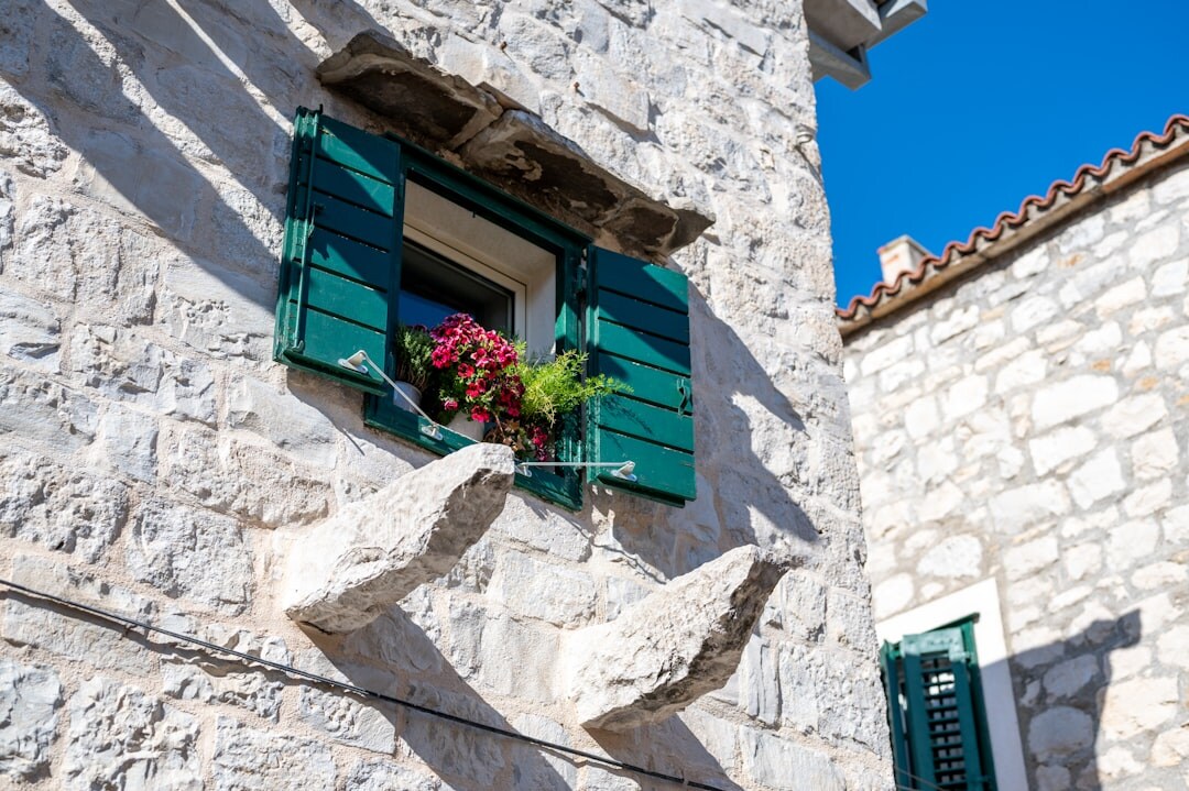 Sunlit narrow street with drying laundry in Split